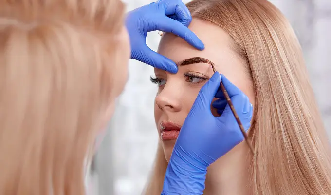 Мастер-бровист выполняет окрашивание и построение архитектуры бровей кистью