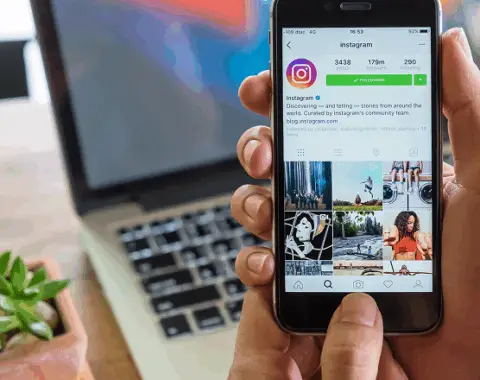 هاتف ذكي بتطبيق إنستغرام المفتوح في اليد، يوضح مقالة حول خطة محتوى جاهزة لجذب أول العملاء من وسائل التواصل الاجتماعي